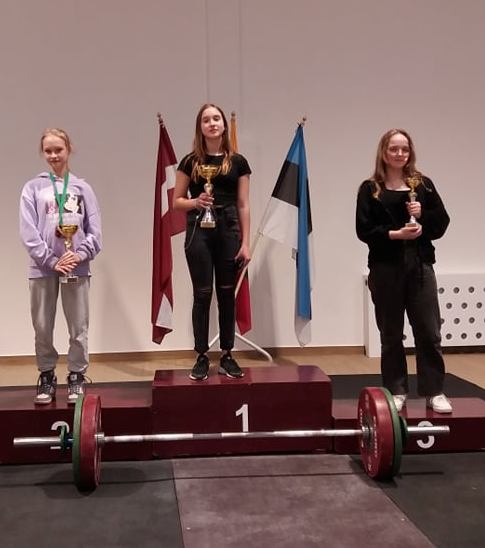Evaldo  Zaniausko  nuotraukoje - ant  garbės  pakylos  antrojo  laiptelio  A. Jonušaitė  (kairėje) 