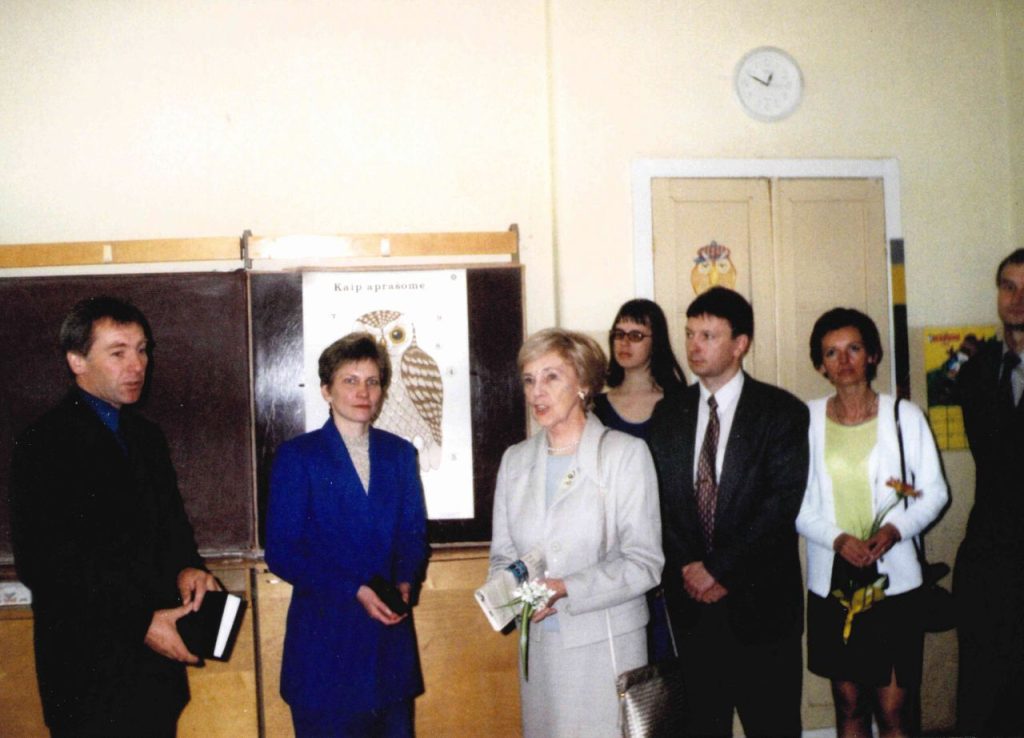 Alma Adamkienė vizito Alsėdžių gimnazijoje metu 2001 metais. Iš kairės pirmoje eilėje: tuometinis mokyklos direktorius Leonas Mockūnas, mokytoja Violeta Rimkuvienė, ponia Alma Adamkienė, tuometinis Seimo narys, dabar Plungės rajono savivaldybės meras Audrius Klišonis, jo žmona Inesa Klišonienė