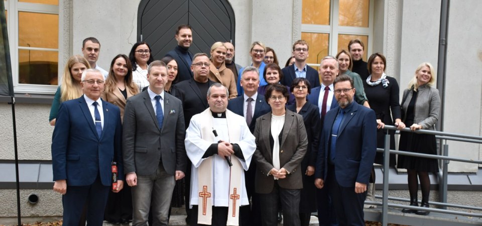 Renginio dalyviai prie atnaujinto „baltuoju mūru“ vadinamo pastato