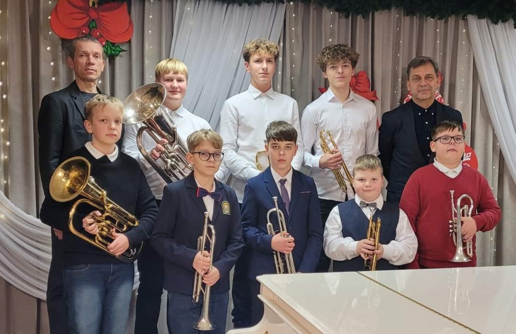 Silvos Galvadiškytės nuotraukoje V tarptautinio vaikų ir jaunimo solistų ir duetų varinių pučiamųjų instrumentų estradinės ir džiazinės pjesės konkurso „Grok - improvizuok 2023“ laureatai ir jų mokytojai. Pirmoje eilėje iš dešinės: Lukas Petreikis, Jurgis Šinkūnas, Simas Pučinskas, Žygimantas Pavlovičius, Martynas  Andriekus. Antroje eilėje iš dešinės: mokyt. metod. Aivaras Alminas, Mantas Gutauskas, Kristupas Končius, Nikolas Šiškovas, mokyt. eksp. Artūras Urniežius. 
