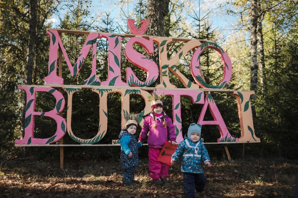 Vaikai šalia užrašo „Miško burtai“