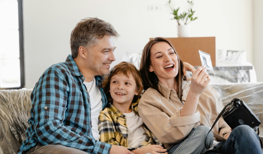 Vyras ir moteris šypsosi laikydami baltą išmanųjį telefoną