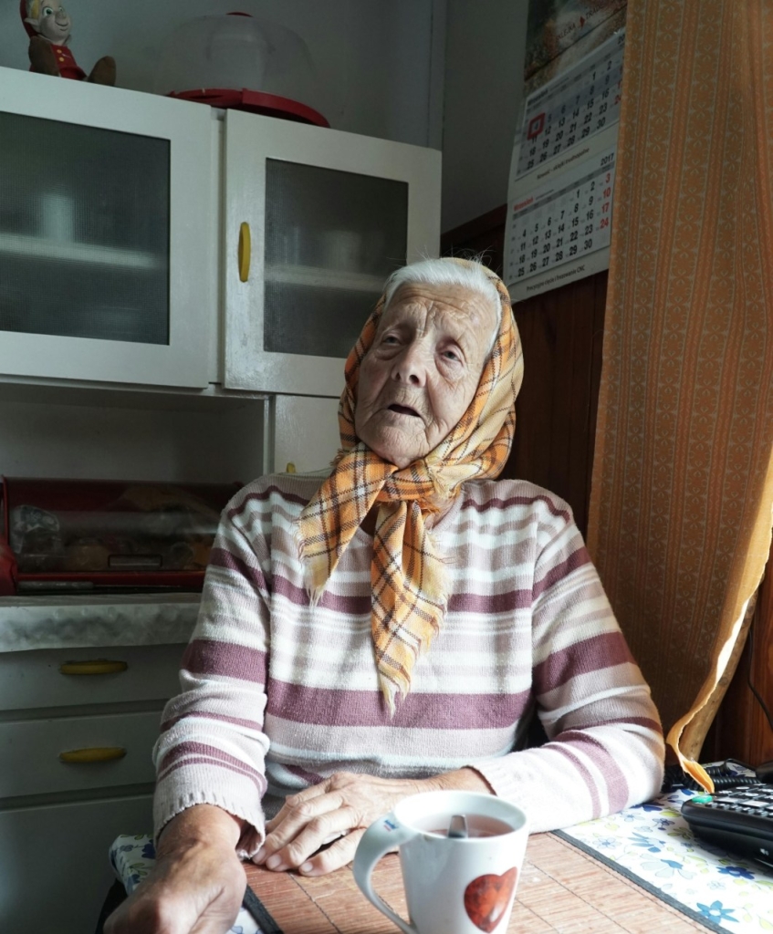 Pagyvenusi moteris su karšto gėrimo puodeliu