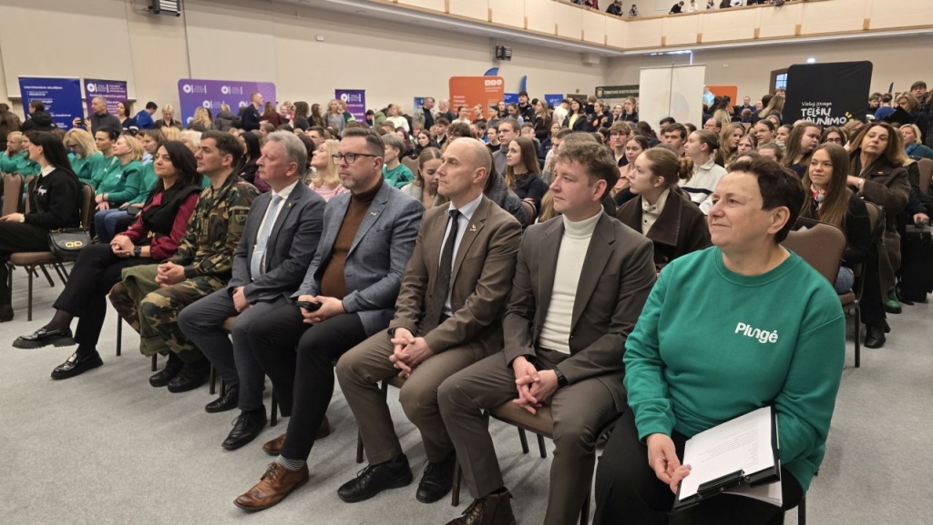 Dalyviai susėdę žirgyno salėje