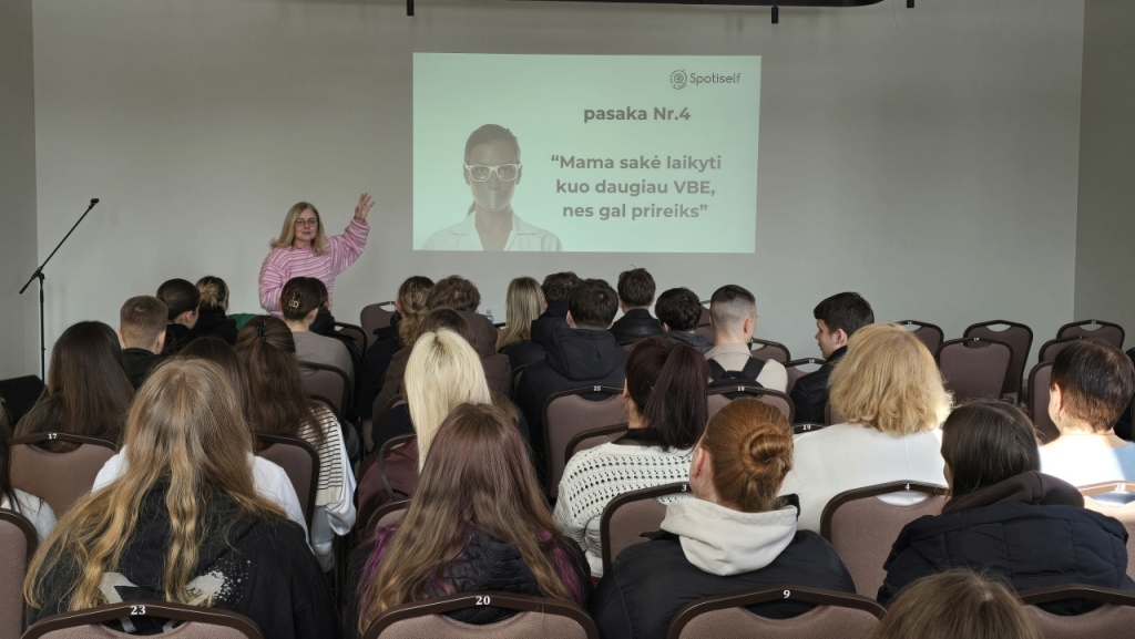 Dalyviai salėje ir ant sienos rodoma skaidrė